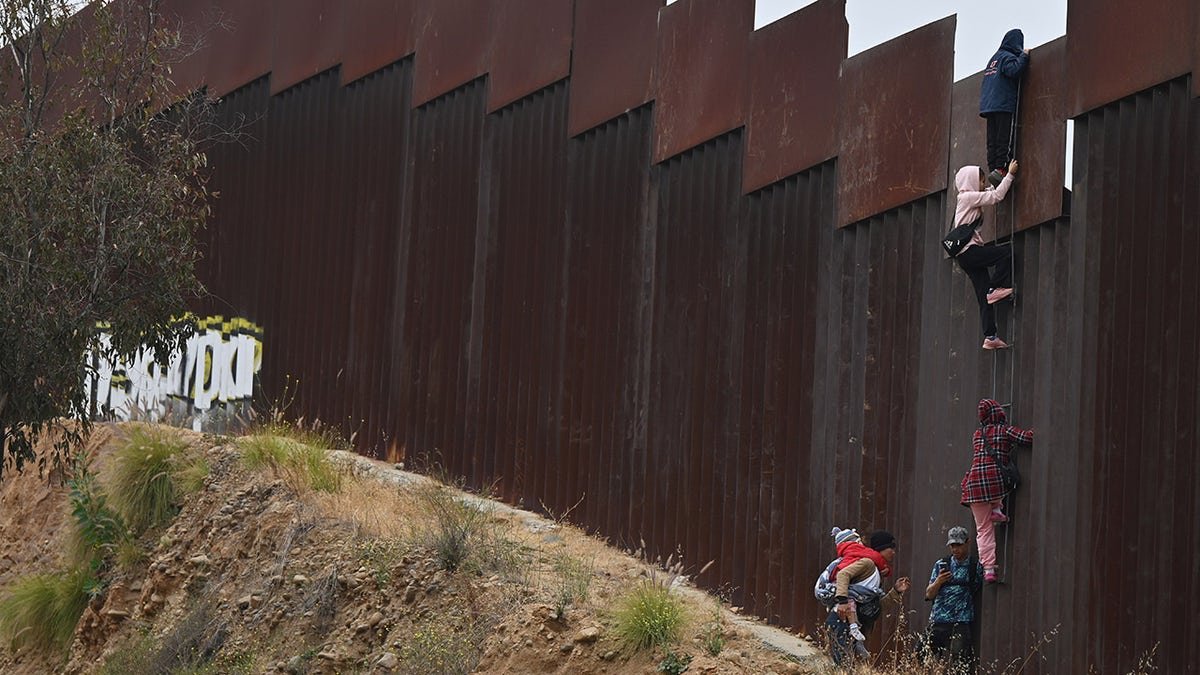 Tijuana, Mexico - June 7: A group of adult immigrants and children was smuggled on the borders of Tijuana San Diego, where they climb the wall to search for asylum in the United States in Tijuana, Baja California, Mexico, on June 7, 2024.