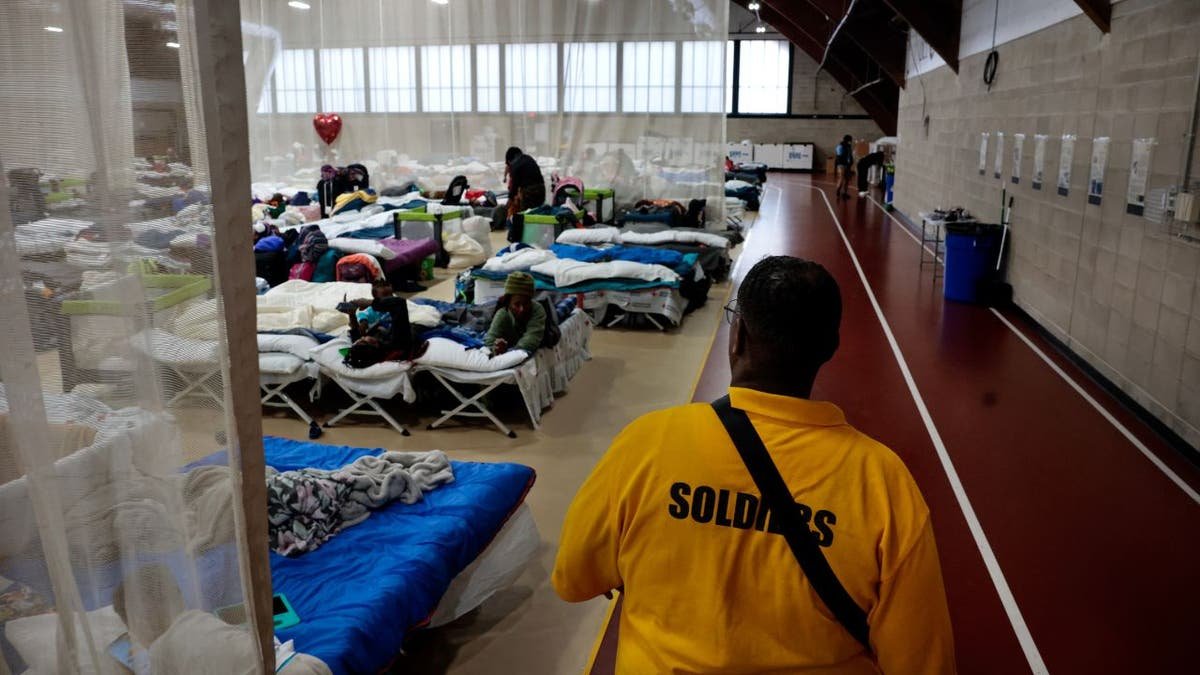 Meshach Little of North Wilkston Security Pirmeter walks in the vicinity of the main living area in the new surplus in the emergency surplus for migrants in the Melnea A. Cass entertainment complex. (Craig V