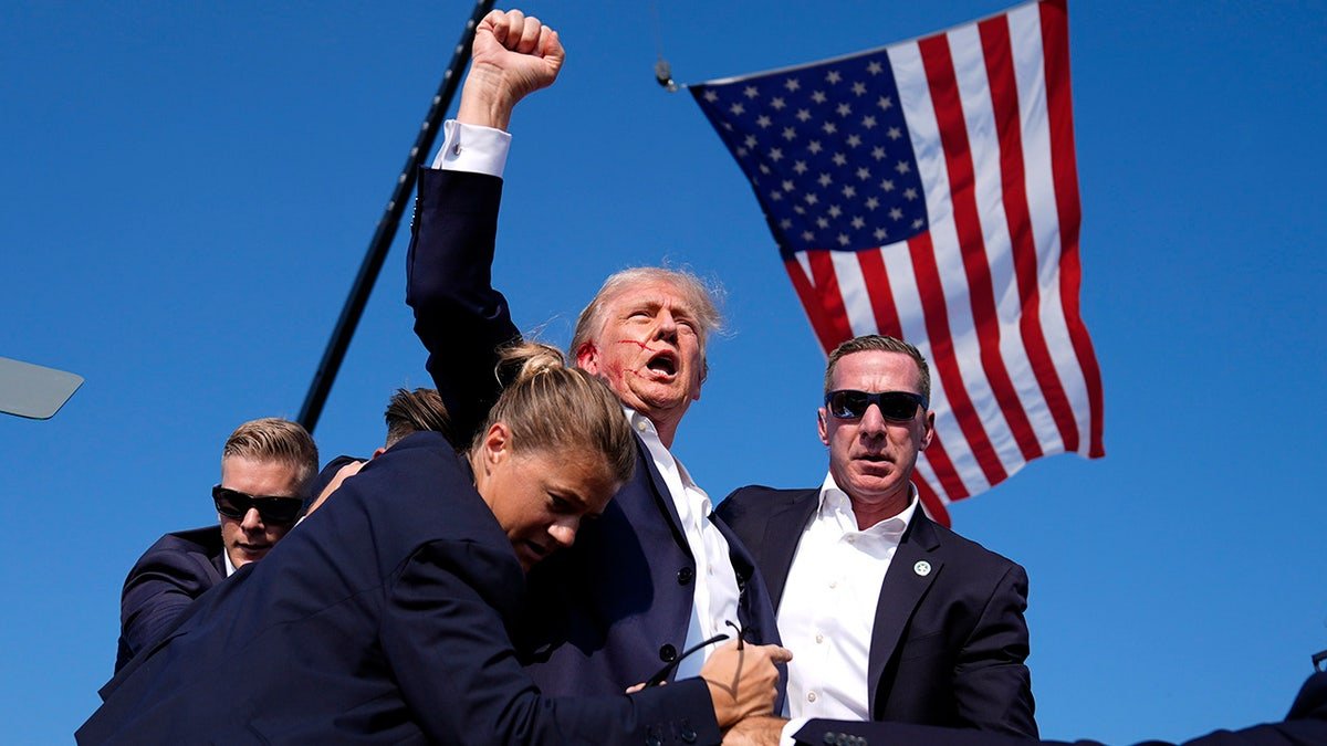 Former President Donald Trump surrounds US secret service agents in a campaign gathering