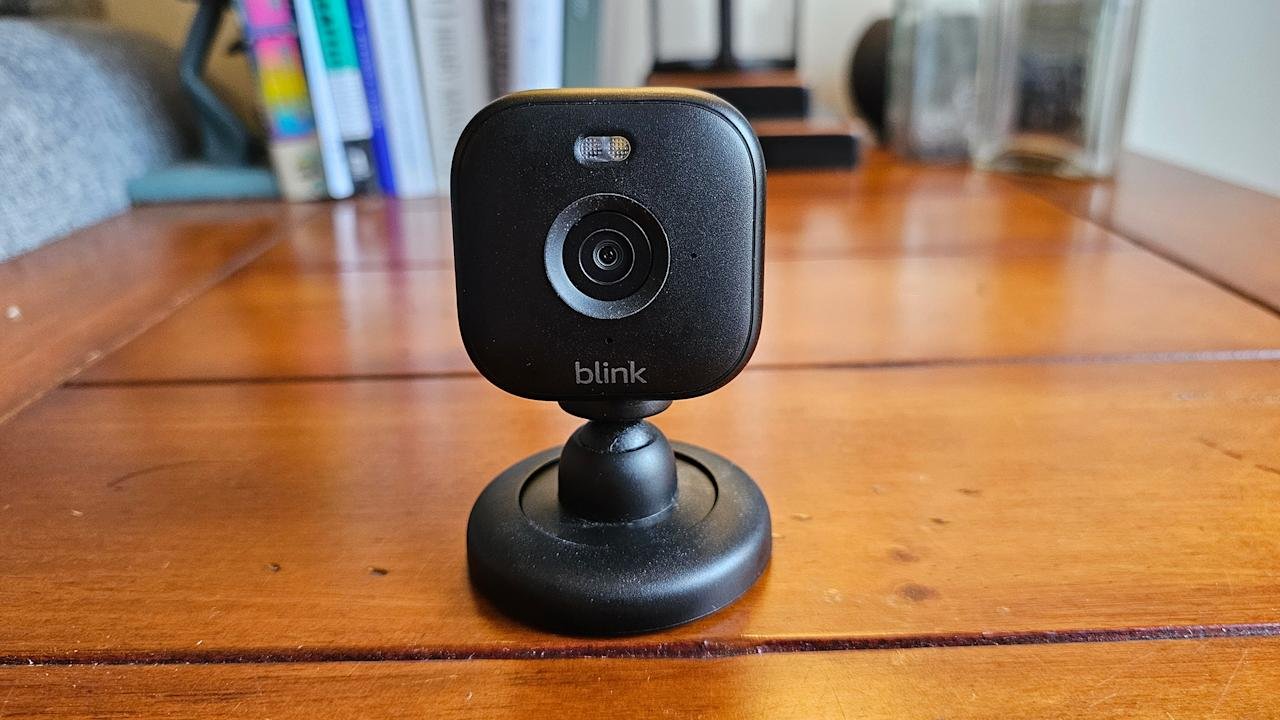 Blink Mini 2 is located on a brown wooden table.