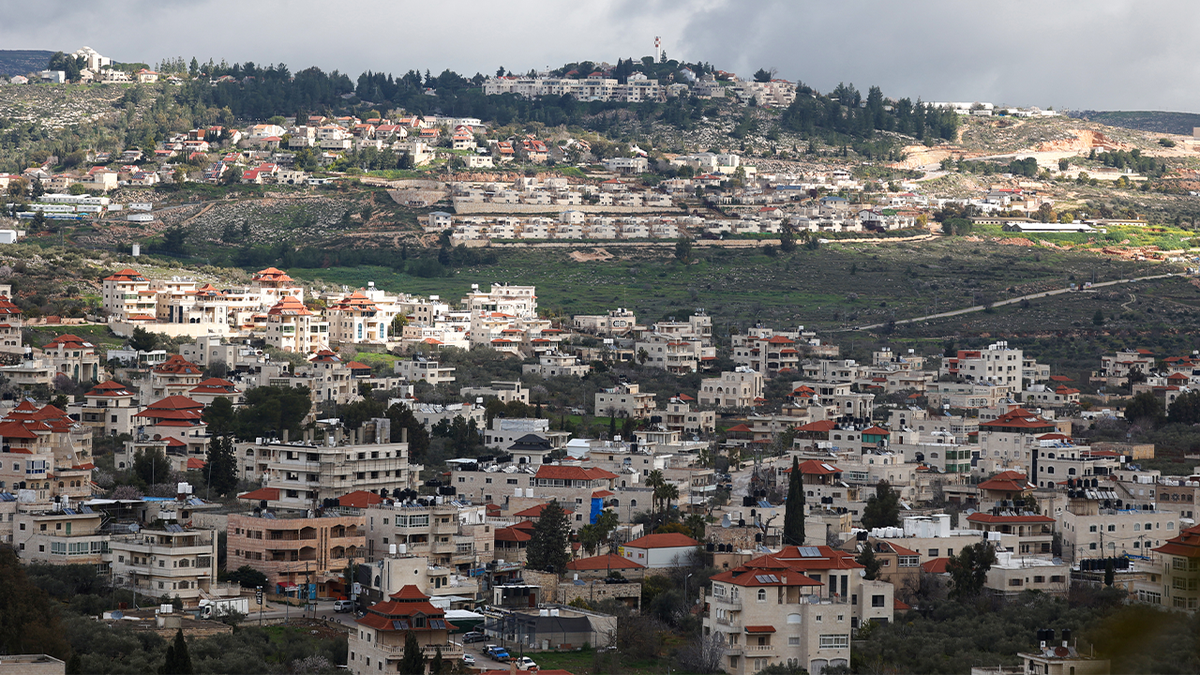 A photo taken in the Turmus Ayya village near the city of Ramallah, the nearby Israeli Shelo settlement in the background, is shown in the West Bank occupied on February 18, 2024.