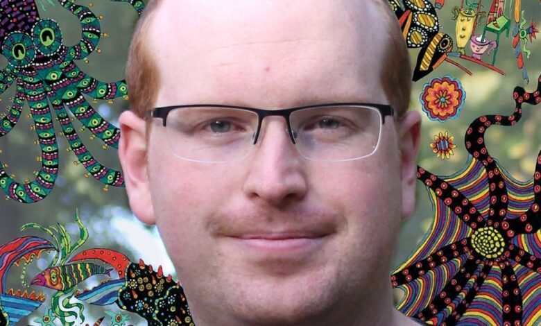 jonathan birch smiling against a background featuring psychedelic illustrations of sea creatures.jpg