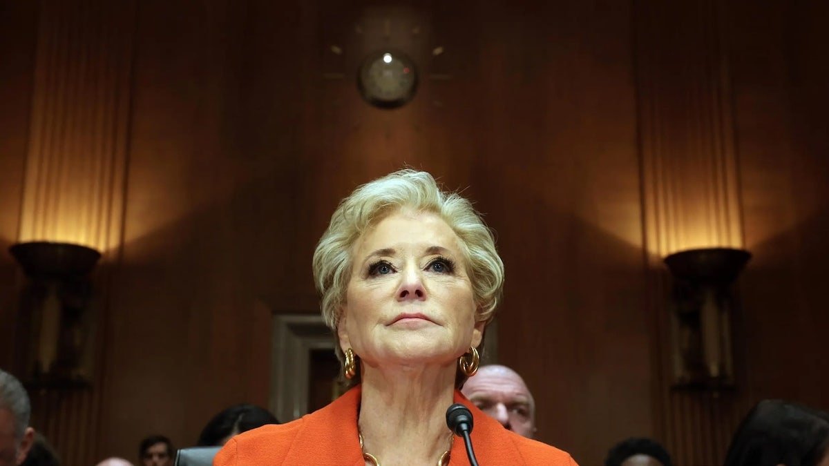 Linda McMahon in front of <a href=