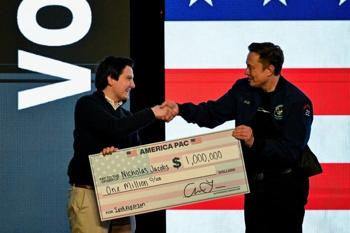 ELON Musk gives a check to an audience member during a march to support the candidate for the conservative state in the elections on April 1 in Green Bay, and Wisconsin