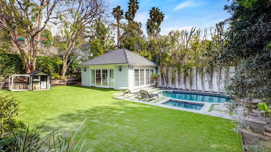 The backyard is characterized by a large herb, a pool and a guest house.