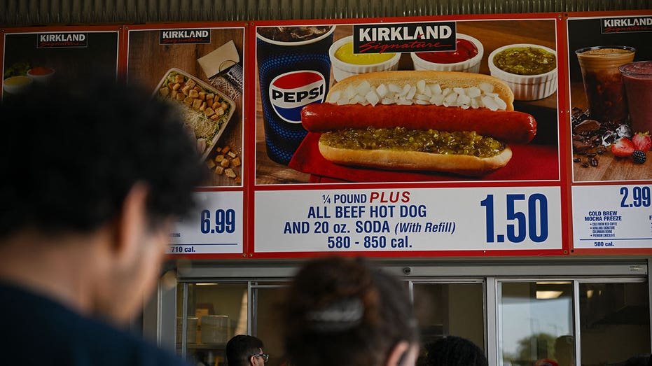 Customers are waiting for the queue to request signs below to sign Costco Kirkland $ 1.50 Hot Dog and Soda Combo, which has maintained the same price since 1985 despite the increase in consumer and inflation prices, in the dining court outside the Costco Whilesale Warehouse store in Inglewood, California,