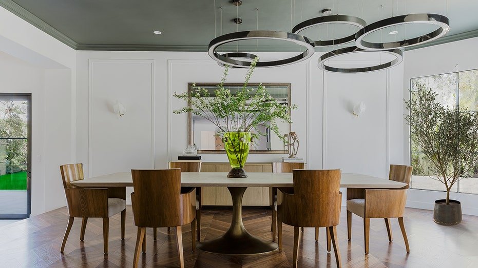 The dining room features unique lighting equipment hanging over the table.