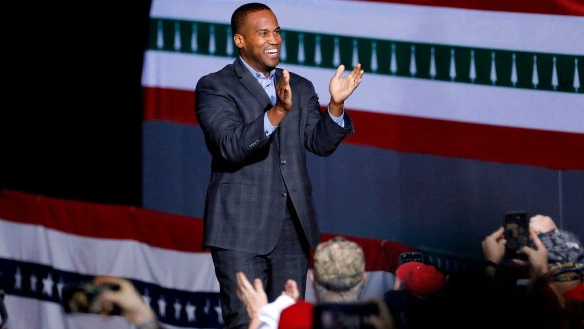 Representative John James speaks in a march
