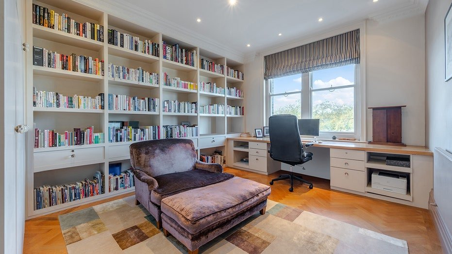 The office includes the shelves of compact books and a large purple chair in the middle.