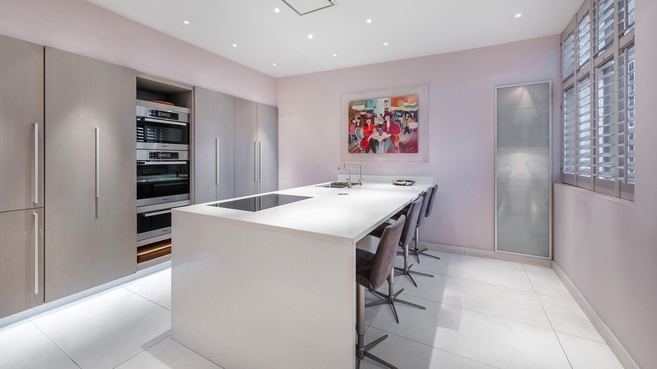 The elegant kitchen features a large island for dining in a center.