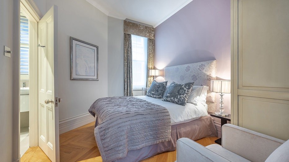 The guest bedroom features purple walls and a bed with purple sheets.