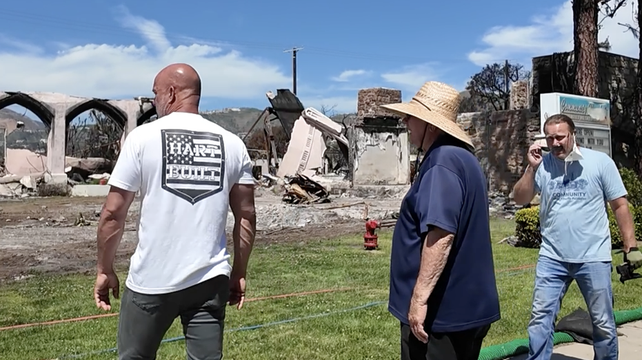 Three people staring at the burning church.