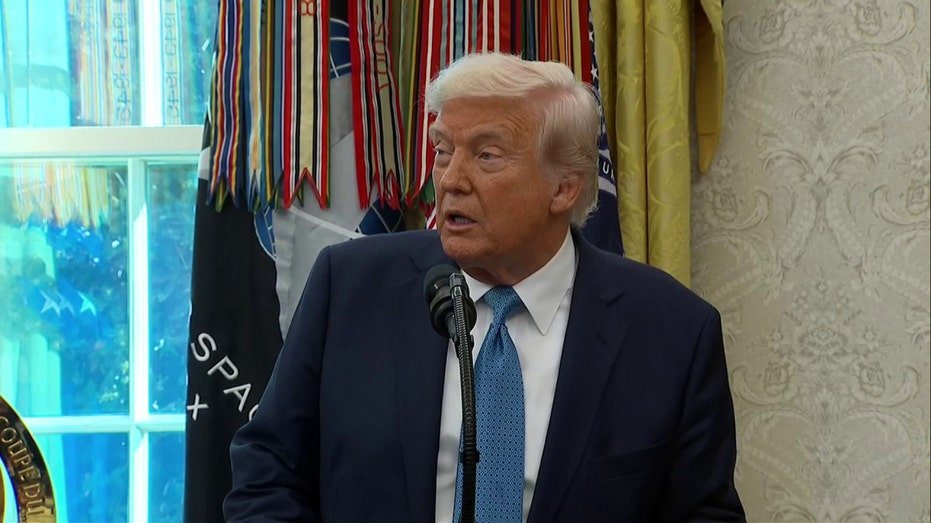 Donald Trump wears a blue suit and a tie of conversations in front of the microphone at the Oval Office
