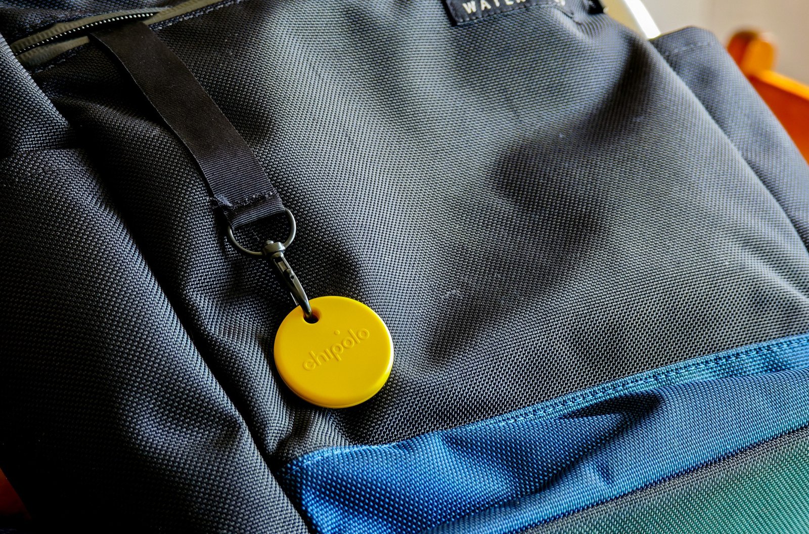 A Chipolo Pop tracker attached to a backpack
