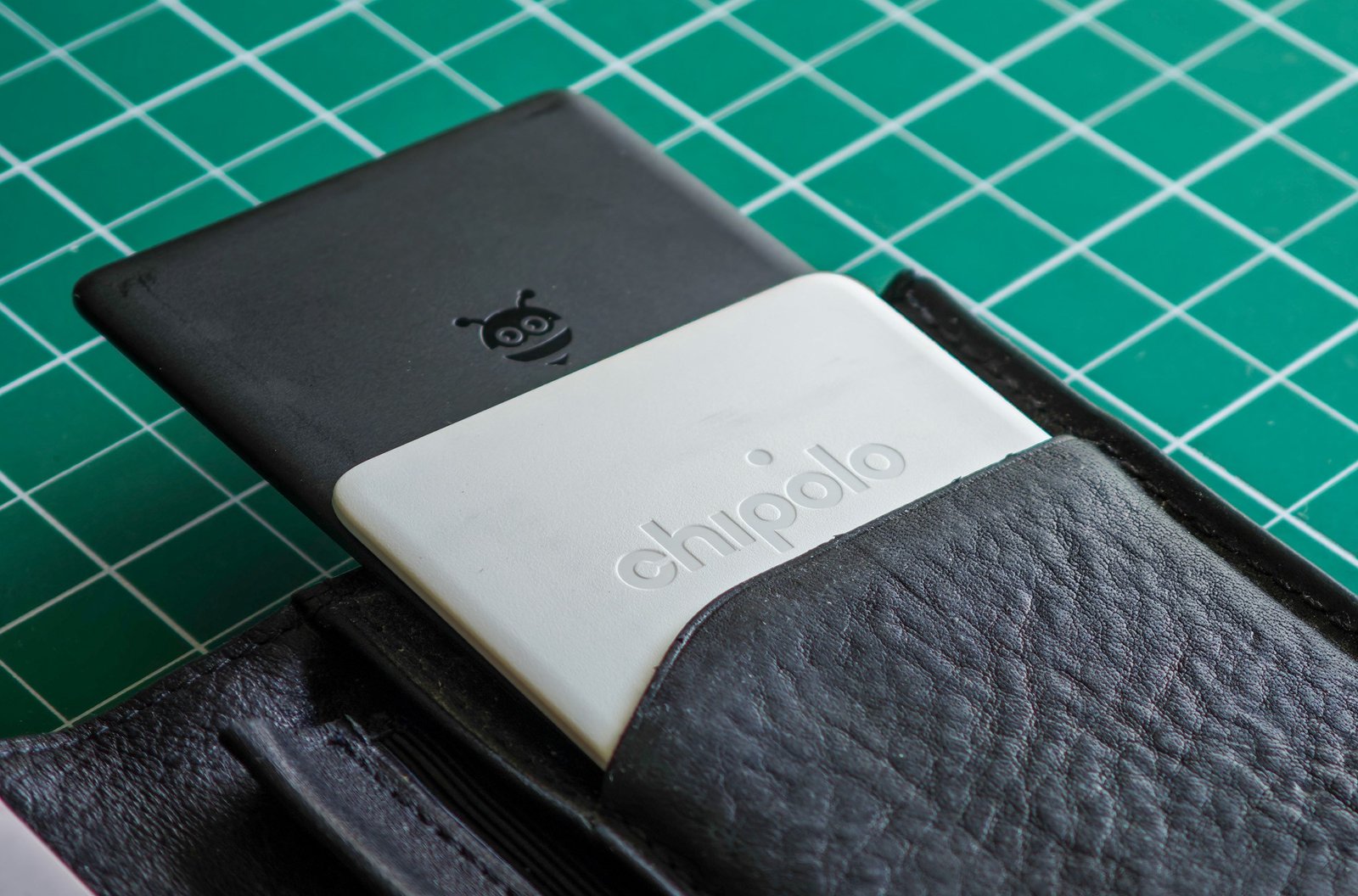 A Pebblebee Card and Chipolo Card sticking out of a wallet