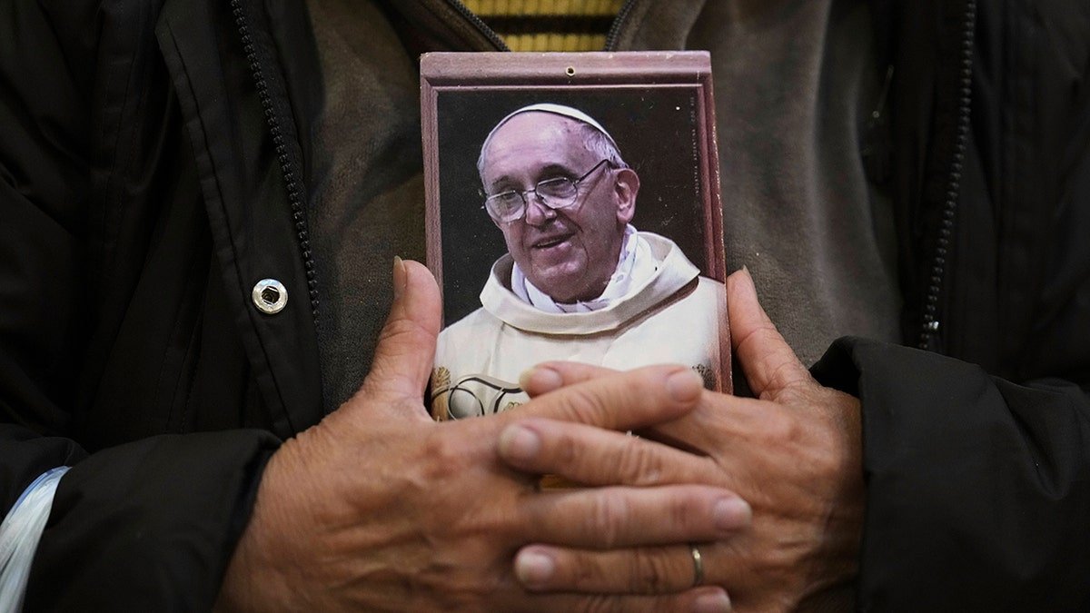 A picture of Pope Francis Carades in the hands of pilgrims