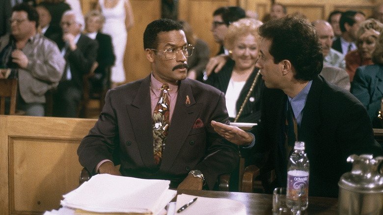 Jackie Chilis (Phil Morris) and Jerry Sinfield (himself) speak in court at Sinfield