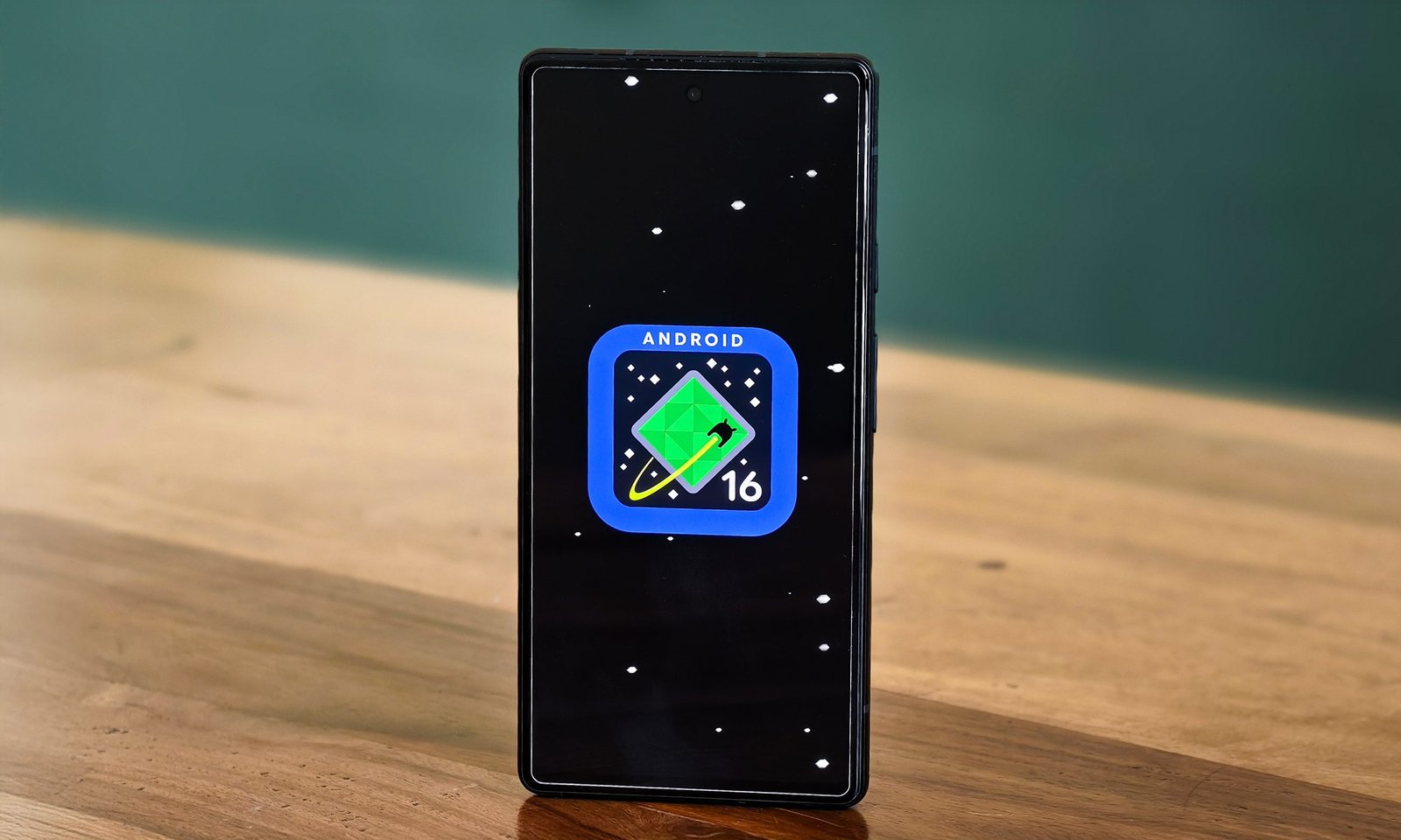 Android 16 Logo on Google Pixel 6A stands at a table.