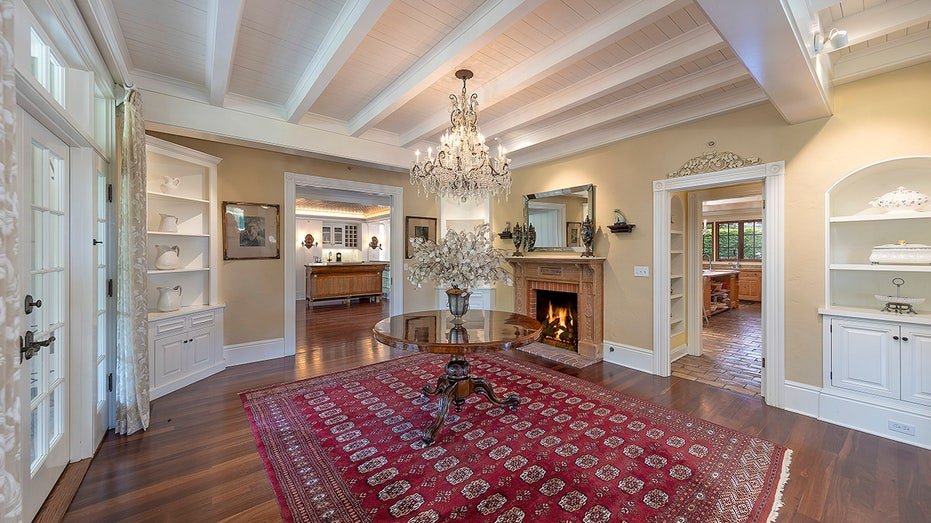 The living room features a fireplace of wood and multiple guaranteed shelves.