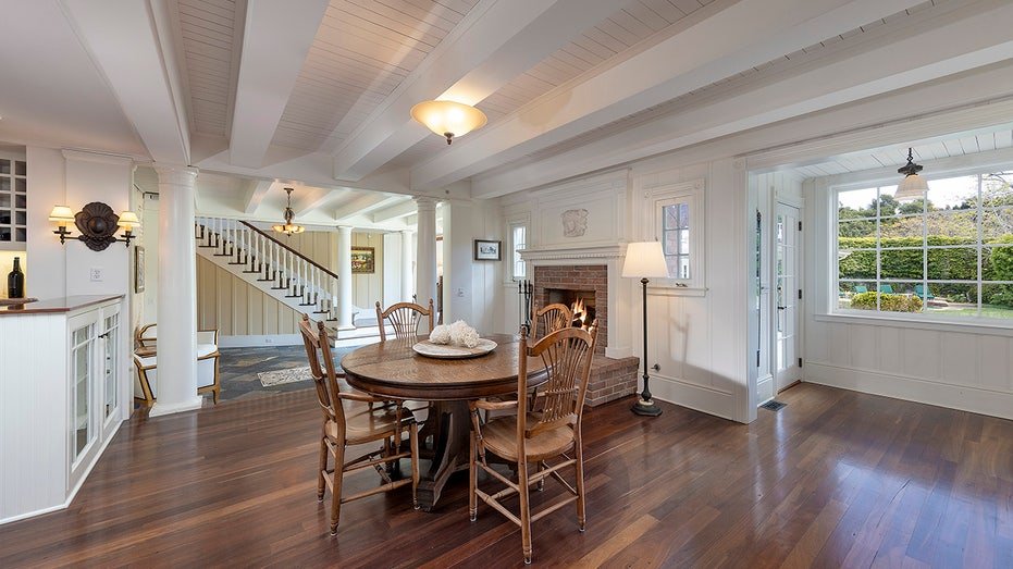 The breakfast room features a wooden fireplace and a round table for four.