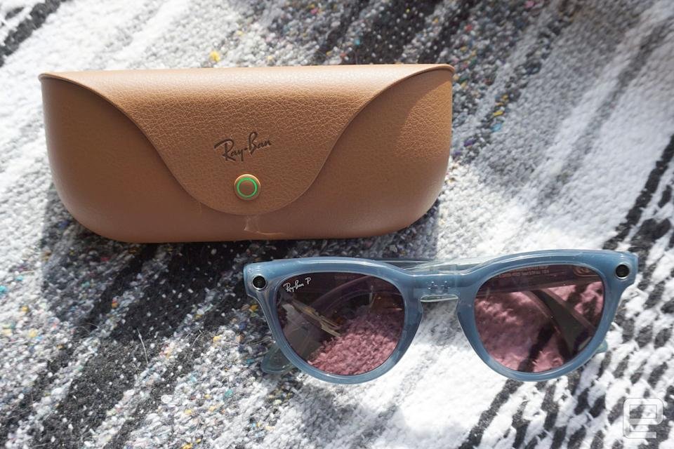Smart sunglasses sitting on a blanket next to the box.