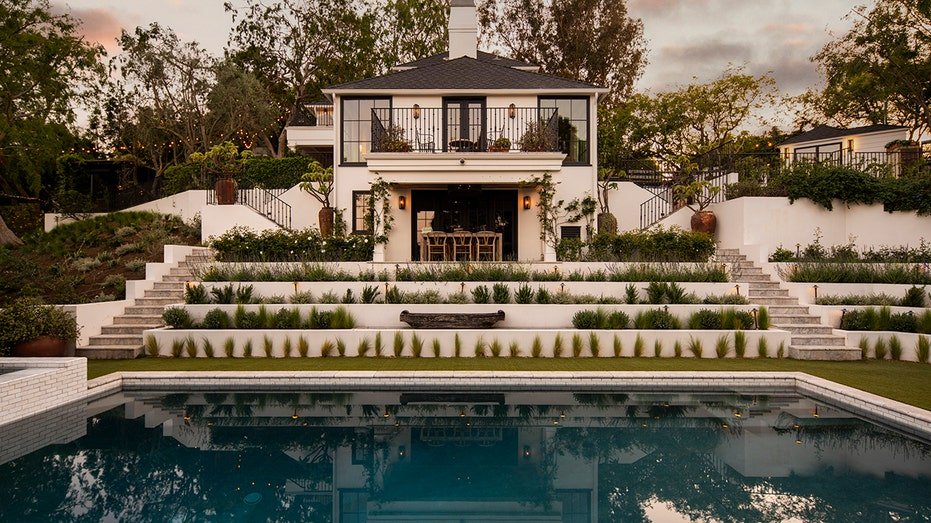 The gradual backyard is also characterized by a second open -air dining area, as well as a large swimming pool.