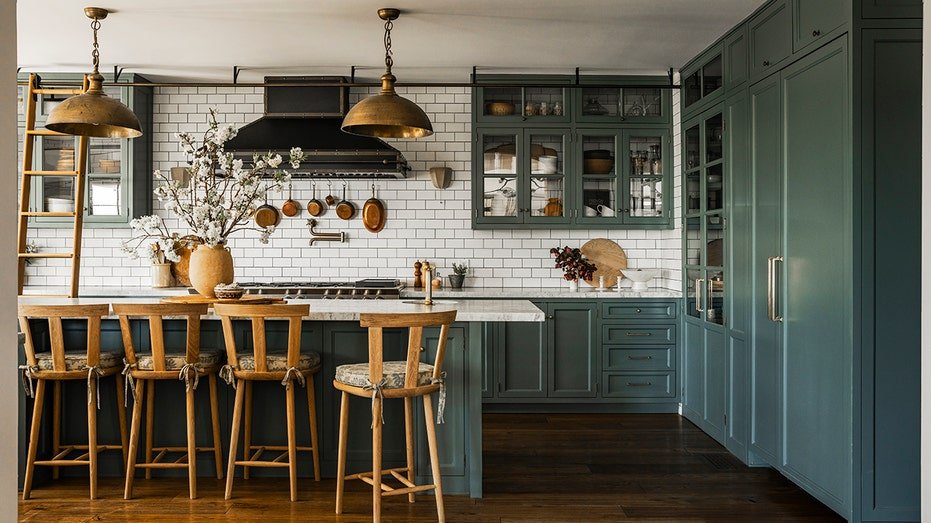 The kitchen contains green blue cabinets and a ladder sliding from one end of the kitchen to the other.