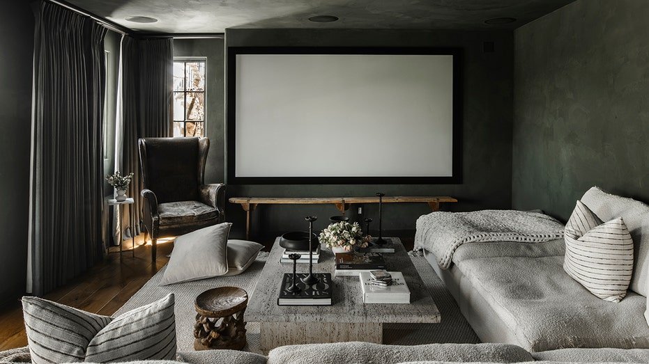 The media room features dark gray walls and a large display.