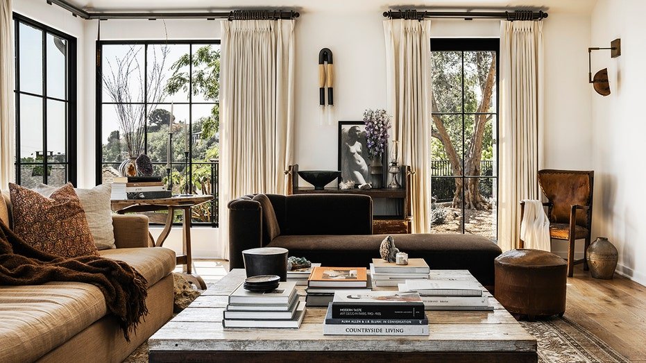 The living room features a firewood and windows extending from floor to ceiling.