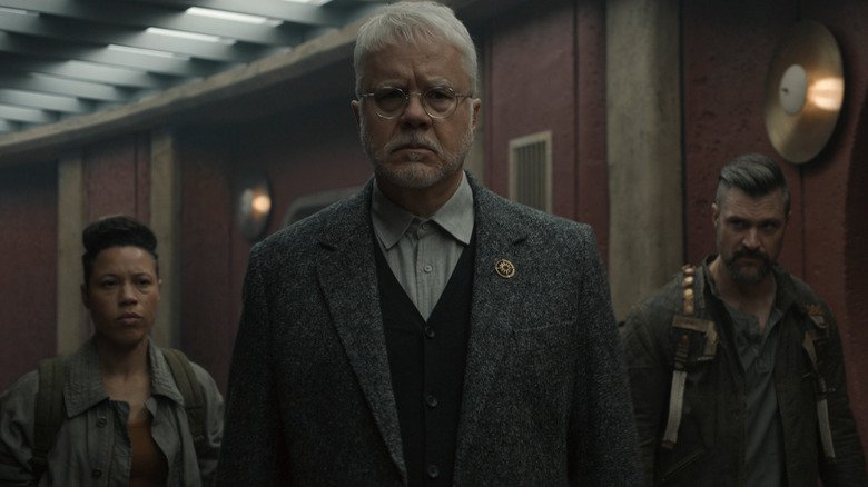 Bernard leads to people from mechanical top of the stairs in a silo