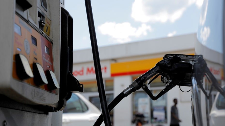 A vehicle at a gas station with a gas pump inside