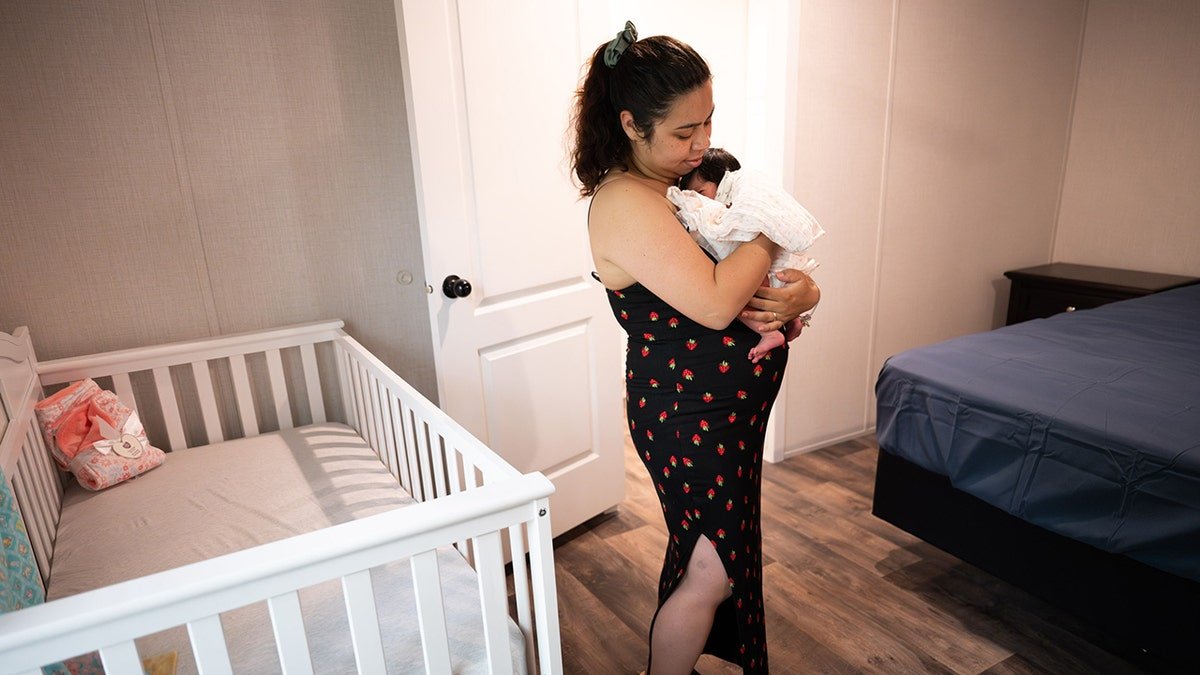 The mother is heading the new baby in the nursery of her new Samaritan house after Hurricane Hellen
