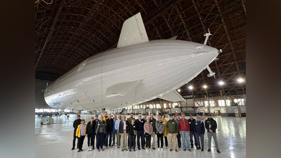 A group photo of students and John J. Jojjan in front of the huge Bathfinder 1 balloon inside the air fold
