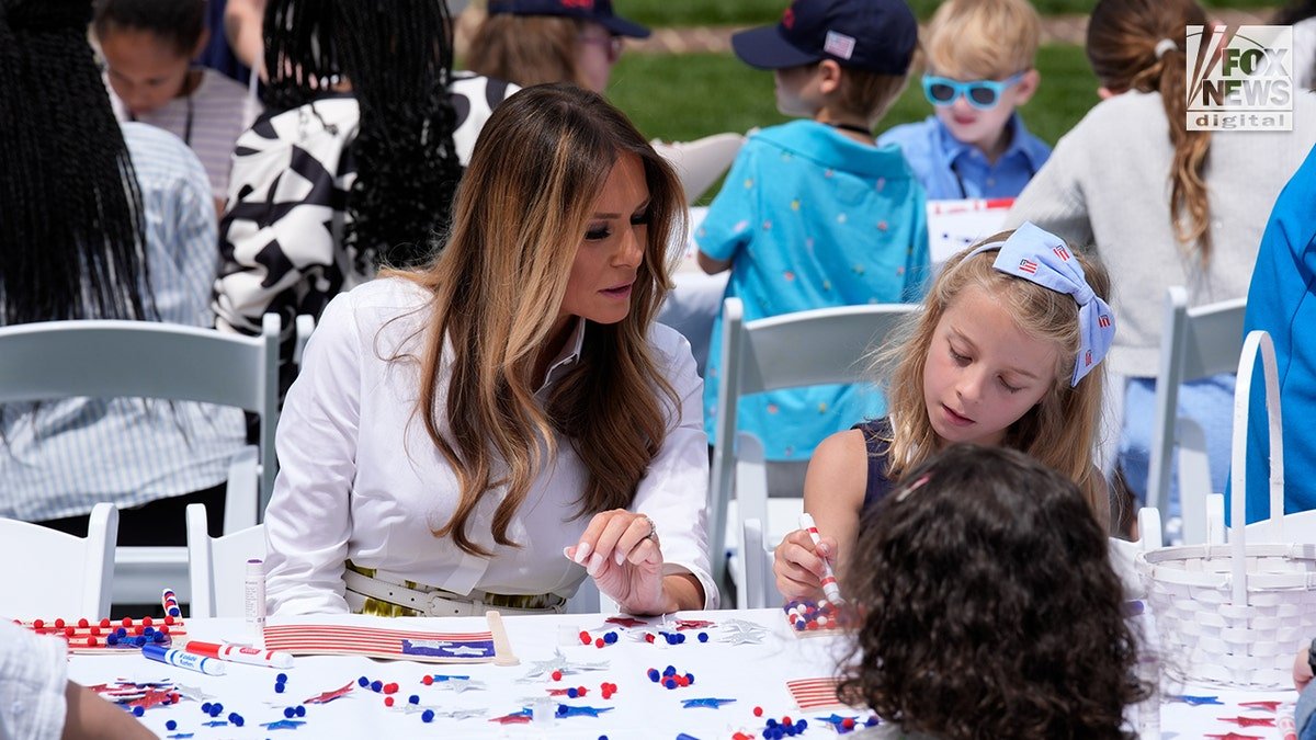 Flotus sits with children in the White House garden.
