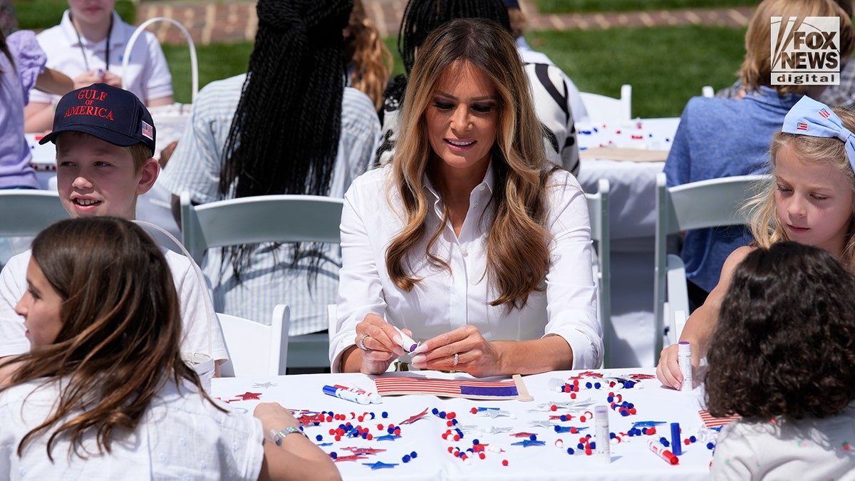 Flotus sits with children in the White House garden.