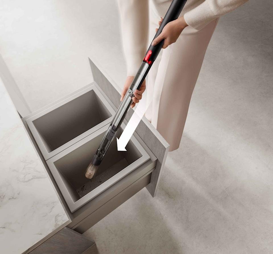 A pair of hands carrying a pencil on the garbage container, with a rebellious arrow indicating the declining movement of the vacuum cleaner.