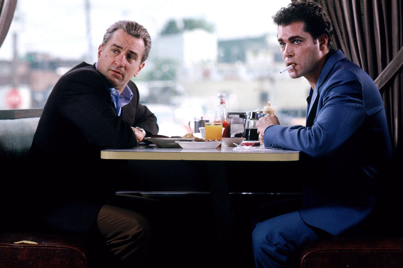 Two men sit on the dinner table and stare.