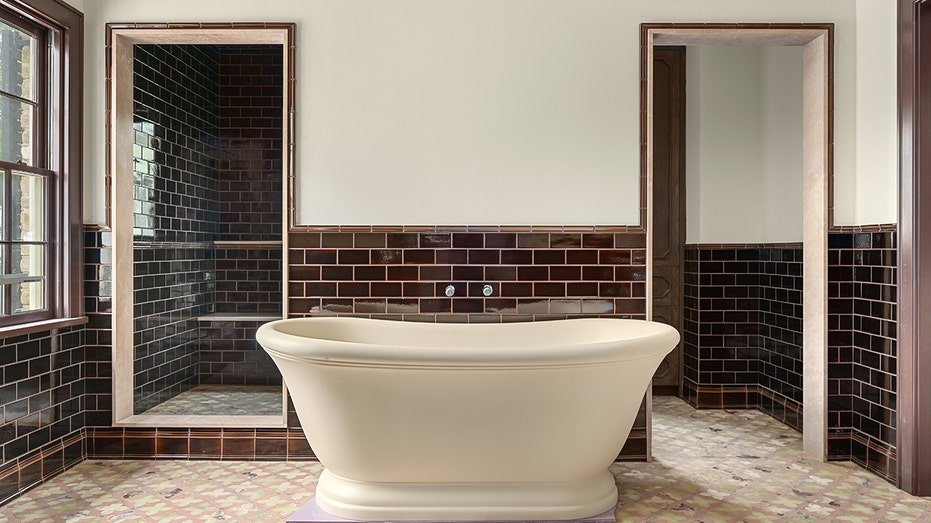 The bathroom features a bath and shower stand.