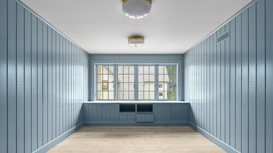 The house also includes a room with blue wooden panels.