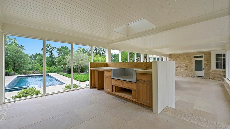 The sun room includes windows from floor to ceiling with views of the pool.