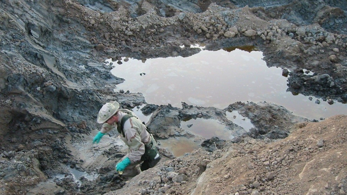 The researcher explores materials in the fossil hole