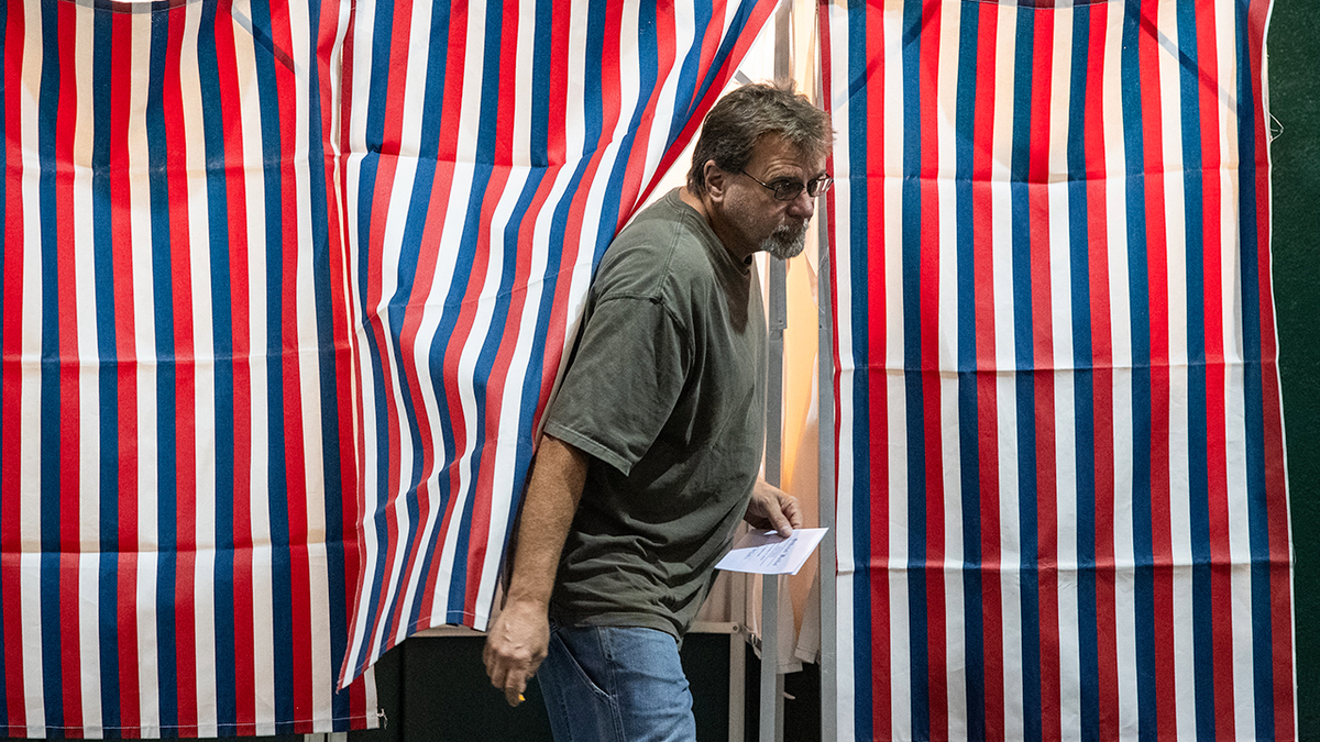 A man comes out of the voting booth.