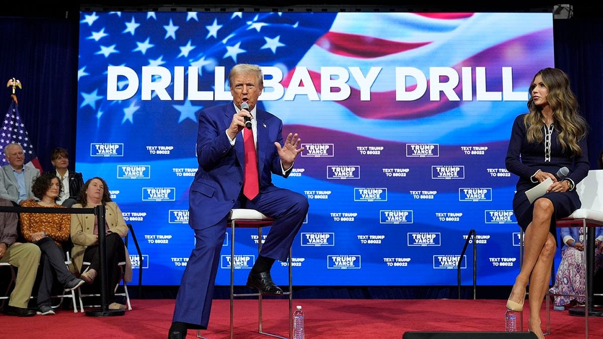 Trump sits in front of the excavation mark on children