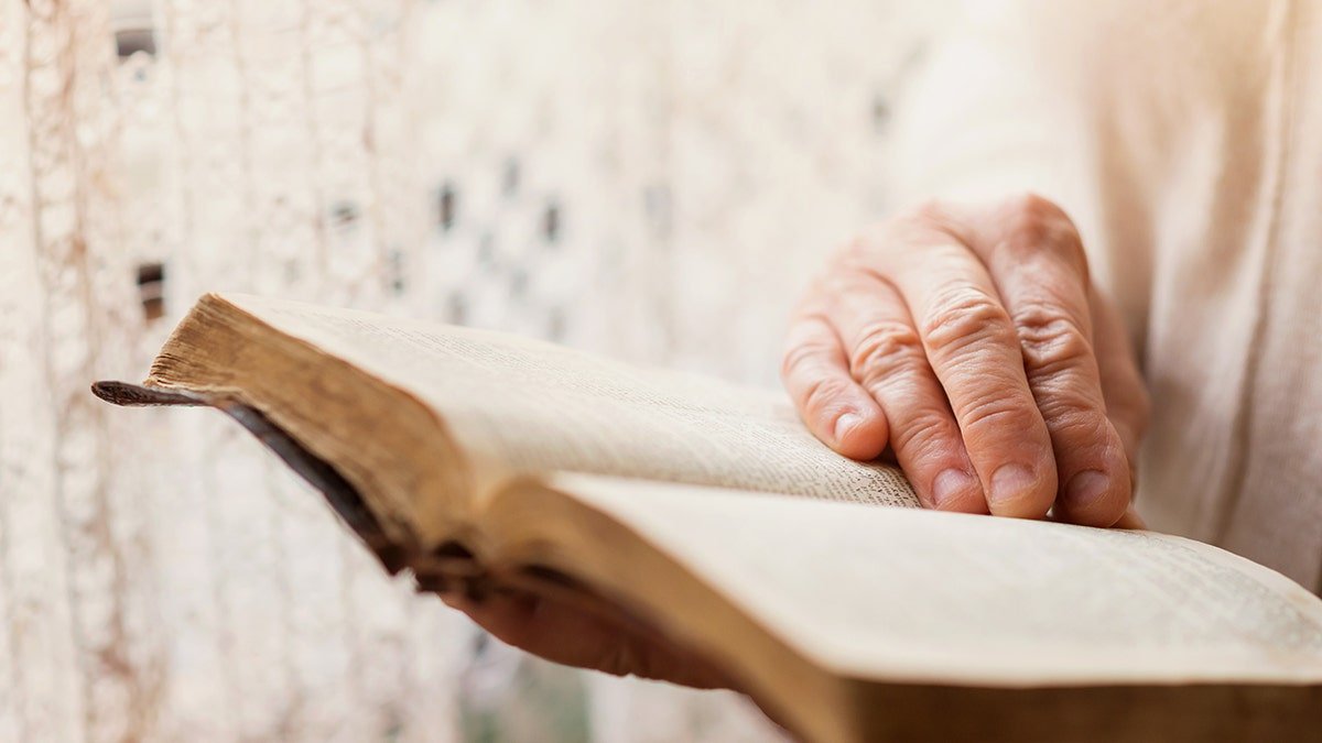 The Bible is read, hands appear