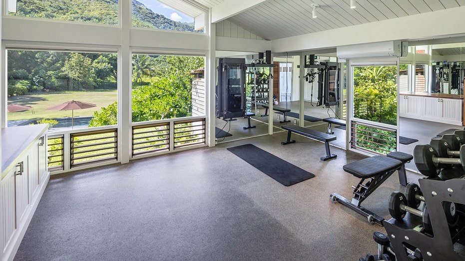 One of the bedrooms was converted into a gym with a weighted rack and a seat.