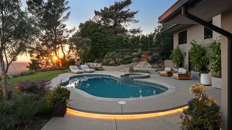 The backyard is also characterized by swimming swimming with the hall chairs around it.