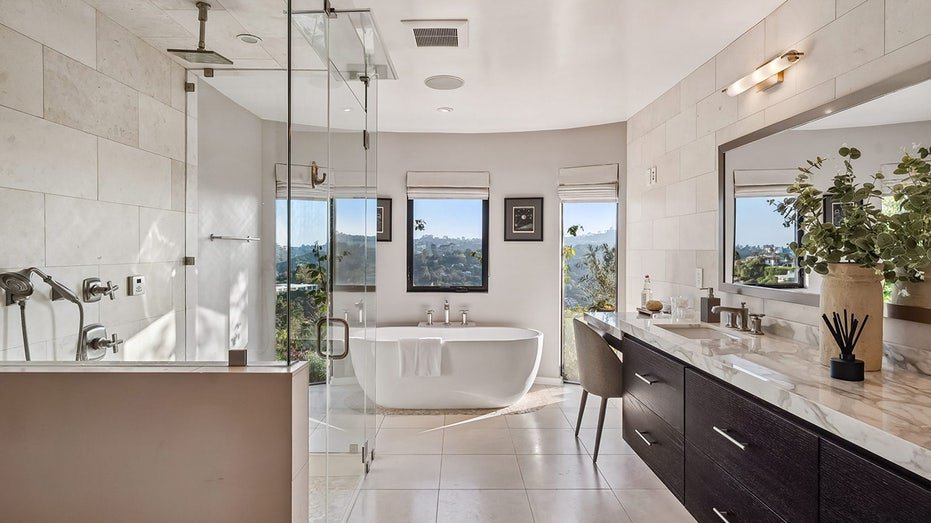 The inner bathroom features a bathtub and standing shower.