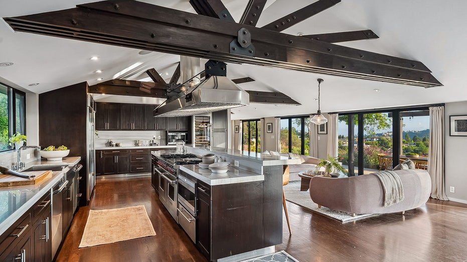 The kitchen features a decentralized island for dining with a double oven and a large stove.