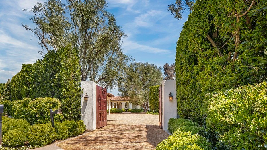 A wooden gate leads to the gravel corridor.