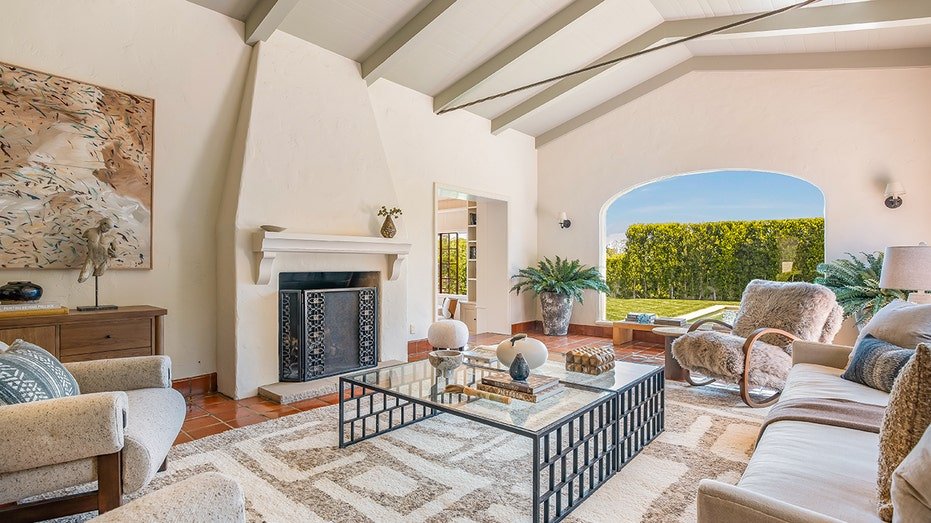 The sunken living room features red clay floors as well as cut and fireplace ceilings that burn wood.